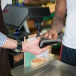 Proses transaksi penjualan di kasir toko menggunakan kartu pembayaran